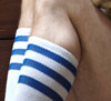 top of white and blue stripey socks on a bended leg