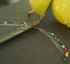 pins with coloured heads arranged to reflecr in mirror like pair of wings